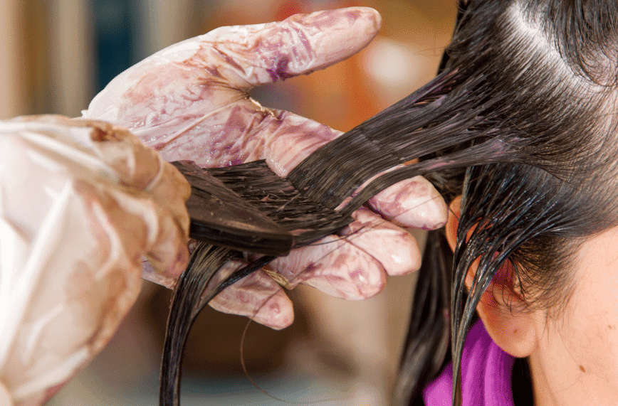 Close-up of hair being colored with dye at a salon.