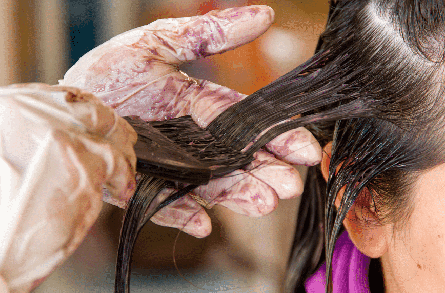 Close-up of hair being colored with dye at a salon.